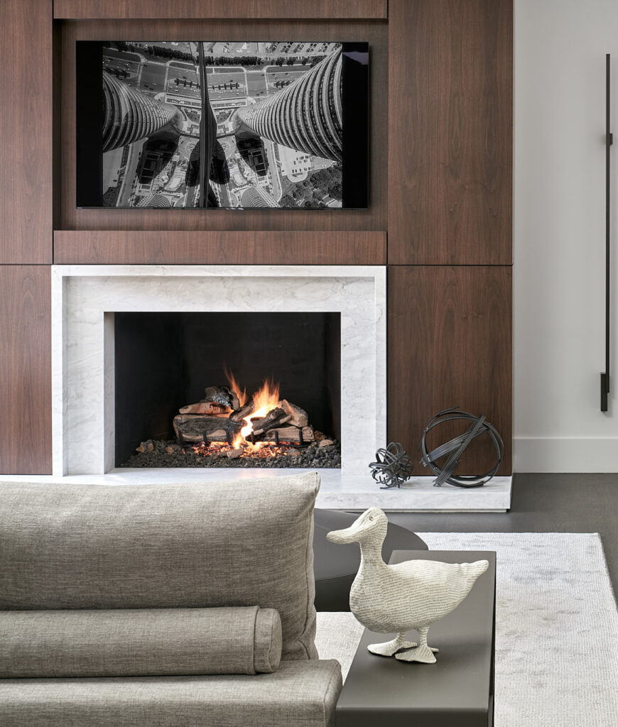 Fireplace in background, sofa and decorative duck in foreground.